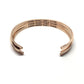 Rose gold bracelet with engraved text on a white background