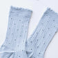 Light blue socks with black polka dots on a white background