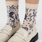 White loafers with beige socks featuring mermaid designs on a white background
