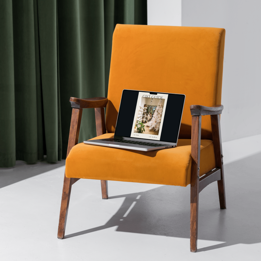 Laptop with Far and Wide's Small Talk Magazine open sitting on an orange chair